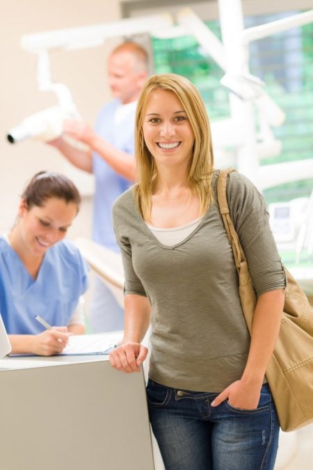 Woman at oral surgery office reception desk
